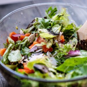 Vibrant and healthy fresh salad with mixed greens and vegetables in a glass bowl.